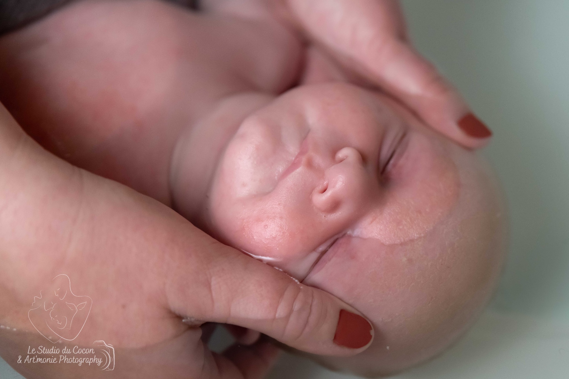 Bébé endormi dans les mains de la praticienne