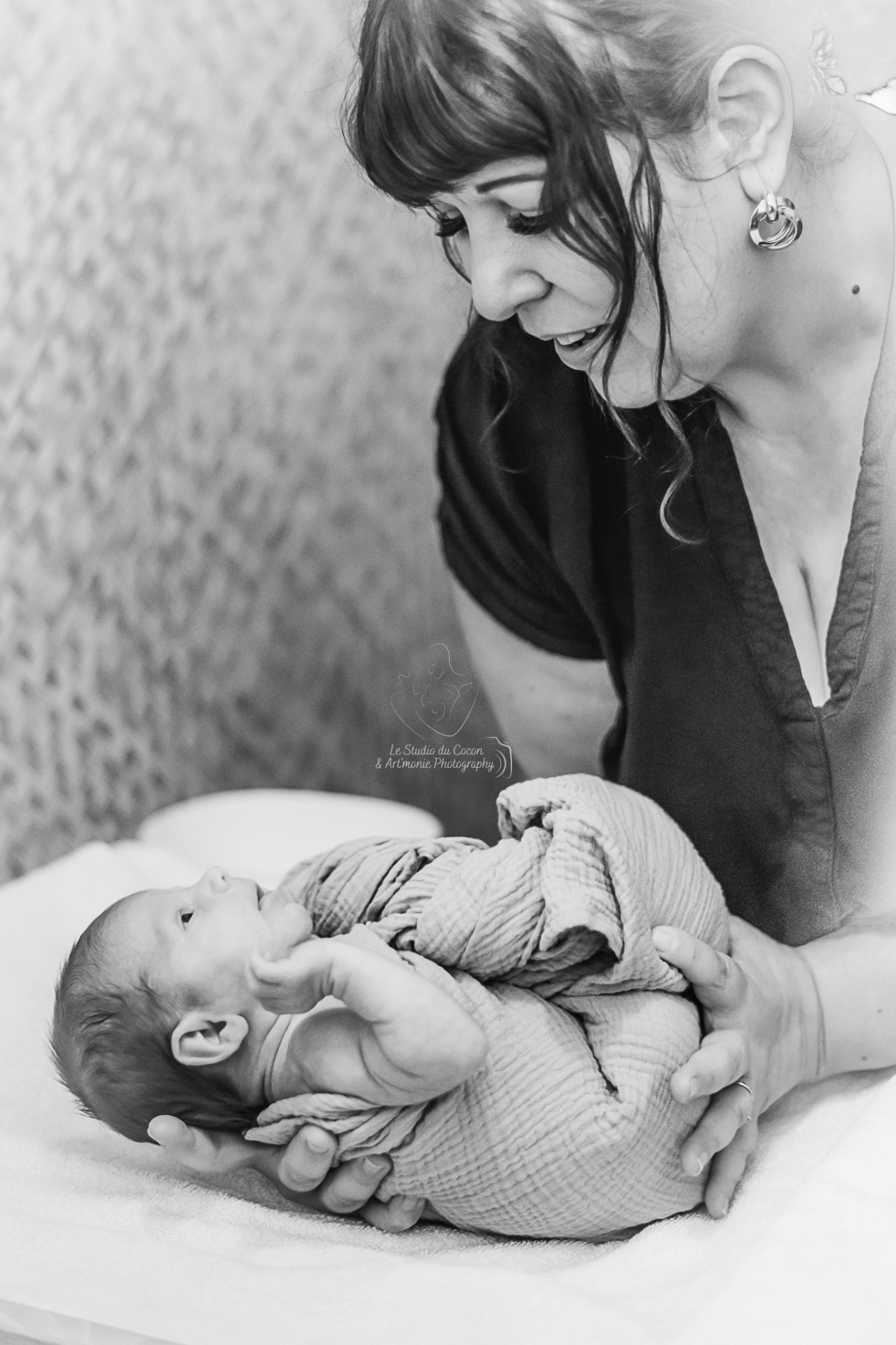 Maman regardant tendrement son bébé emmailloté